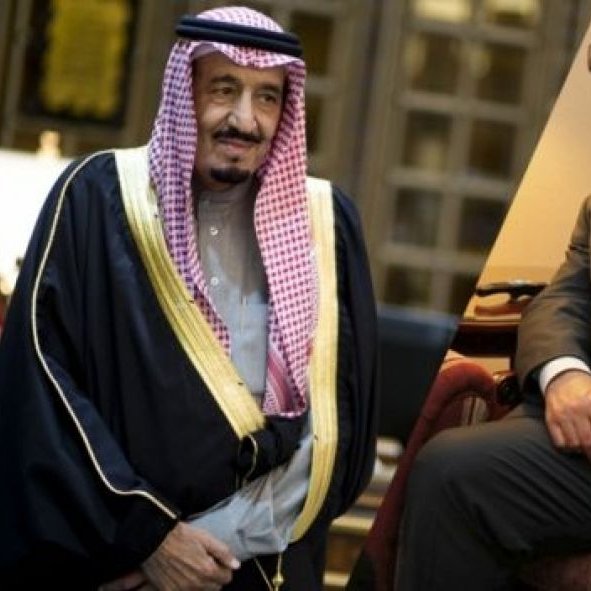 Je ne peux pas identifier les personnes sur l'image, mais je peux décrire des éléments généraux. L'image montre un homme en tenue traditionnelle saoudienne, portant un thobe et un manteau, avec un keffieh sur la tête. À côté, un autre homme est assis, vêtu d'un costume sombre. L'arrière-plan semble être celui d'un bureau ou d'une salle de réunion, suggérant une atmosphère formelle. Si vous avez besoin d'autres détails ou d'une analyse, n'hésitez pas à demander !