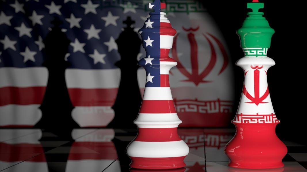تصویر نشان‌دهنده دو مهره شطرنج است که به نمادهای ملی ایالات متحده و ایران تزئین شده‌اند. مهره سفید به پرچم ایالات متحده و مهره قرمز به پرچم ایران منقش شده است. پس‌زمینه تصویر تاریک و مرموز است و حس رقابت و تضاد بین دو کشور را منتقل می‌کند. زمین شطرنج نیز با الگوی خاصی به تصویر اضافه شده که به فضای بازی شطرنج اشاره دارد.