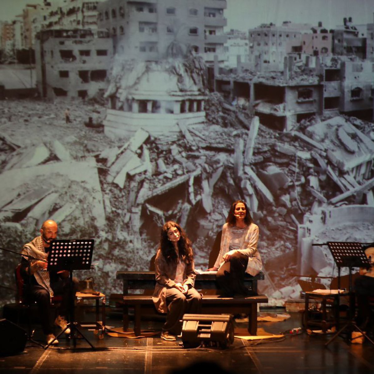 عروض مسرحية مع مجموعة من الفنانين أمام خلفية تدمير.