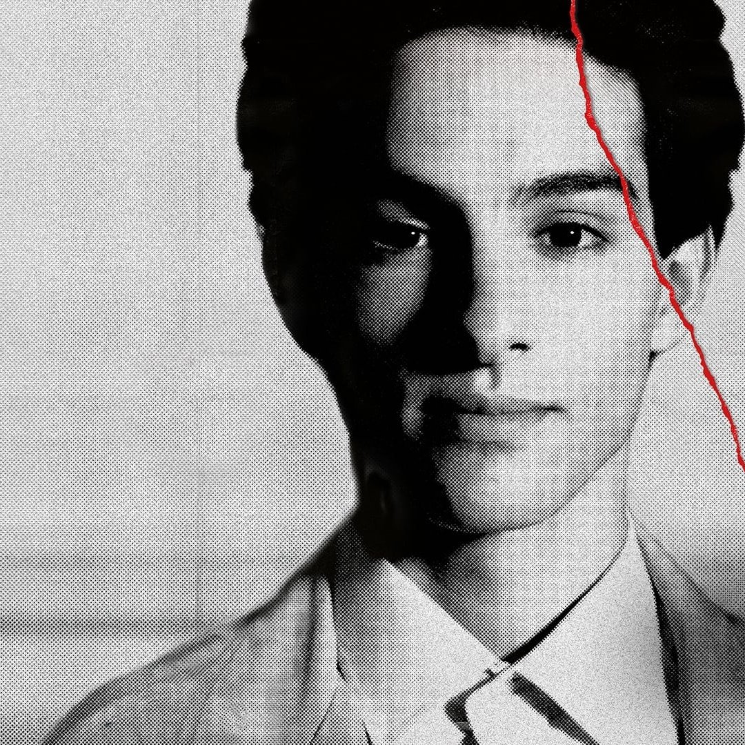 L'image présente un portrait en noir et blanc d'un jeune homme. Son expression est sérieuse et il a les yeux fixés vers l'avant. On peut voir des détails de son visage qui ressortent bien grâce à l'éclairage. Le fond est flou, ce qui met davantage en valeur sa silhouette. Il semble également y avoir un effet de texture sur l'image, ajoutant une dimension artistique.