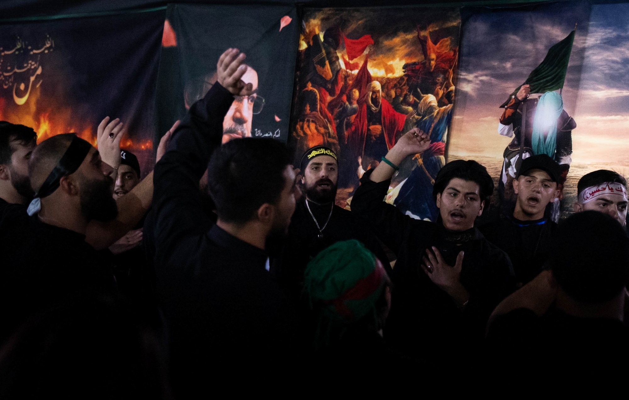 Des hommes en vêtements noirs chantent et montrent des signes de dévotion.