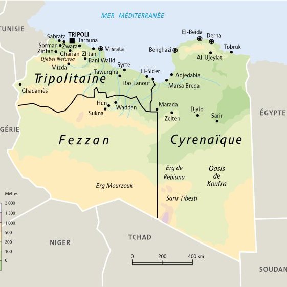 L'image représente une carte de la Libye, divisée en trois régions principales : la Tripolitaine, le Fezzan et la Cyrénaïque. On peut y voir les principales villes telles que Tripoli, Misrata, Benghazi et Tobrouk, ainsi que des routes importantes. Les limites géographiques des différentes régions sont clairement marquées, et la mer Méditerranée est indiquée au nord. Des éléments topographiques comme les déserts et les oasis sont également présents sur la carte.