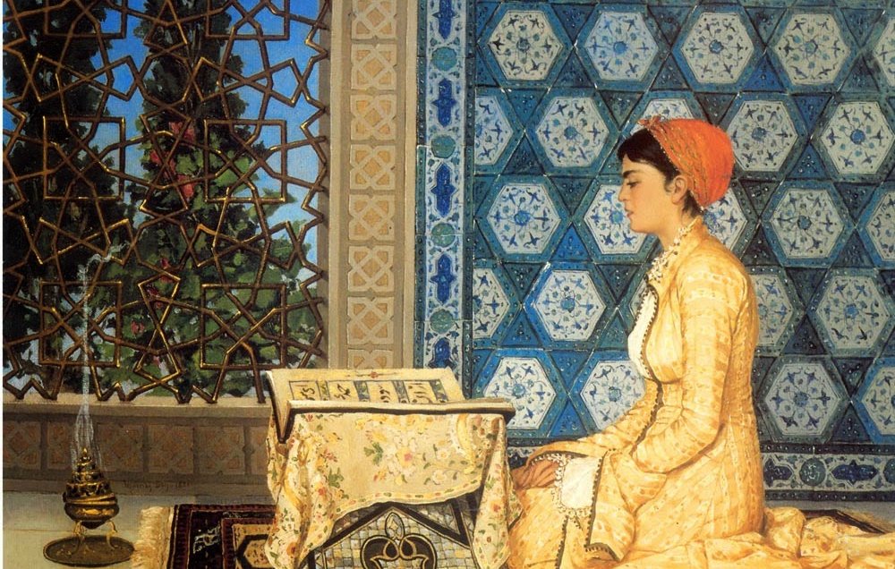 L'image présente une femme assise sur un tapis, vêtue d'une robe jaune ornée de motifs délicats. Elle est concentrée, tournant son regard vers un livre posé sur une table basse. La pièce est décorée avec de magnifiques mosaïques murales bleues et un vitrail qui laisse passer une lumière douce. À côté d'elle, une lampe à huile ajoute une touche d'ambiance chaleureuse. L'atmosphère générale dégage une impression de sérénité et de dévotion.