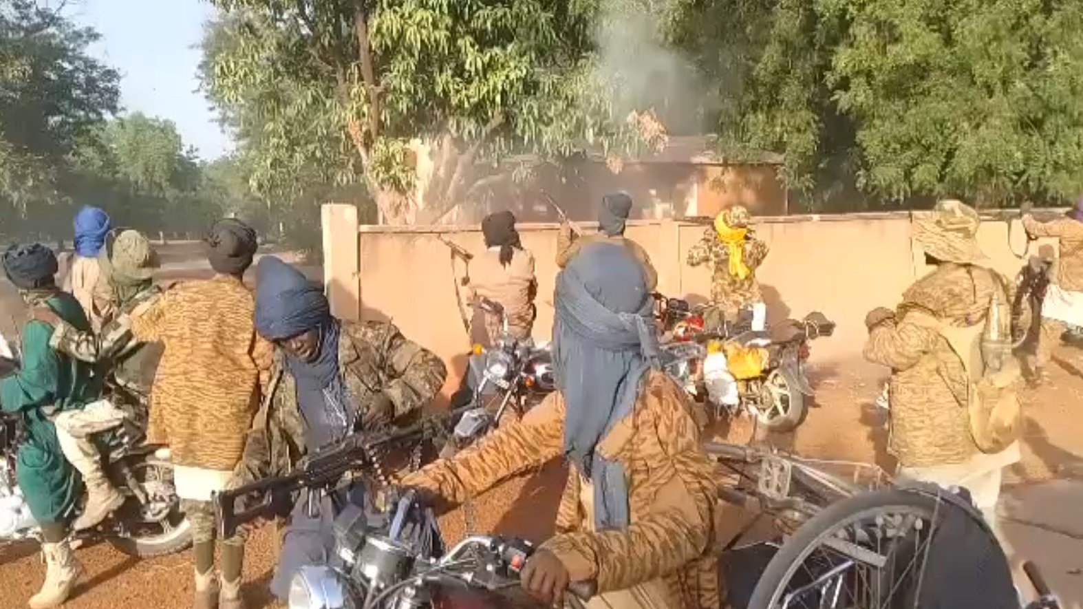 مجموعة من الرجال على دراجات نارية، يرتدون أقمشة تغطي وجوههم، في بيئة غابات.