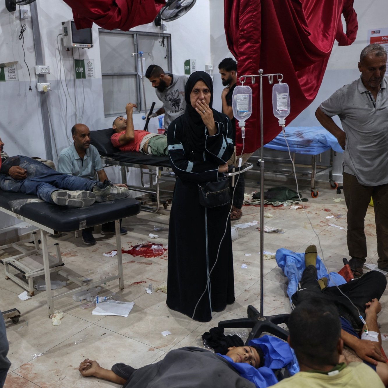Une salle d'hôpital chaotique avec des blessés et des soignants.