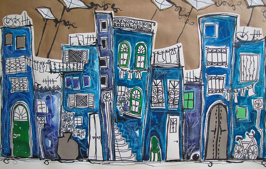 L'image représente une scène urbaine colorée et stylisée. On y voit des bâtiments aux teintes bleues et turquoise, ornés de fenêtres aux formes variées et de balcons. Quelques vêtements sont accrochés au fil à linge, ajoutant une touche de vie à l'ensemble. En arrière-plan, des cerfs-volants volent dans le ciel, donnant une ambiance joyeuse et ludique. Le tout est dessiné avec un style artistique marqué par des contours noirs et des détails charmants.