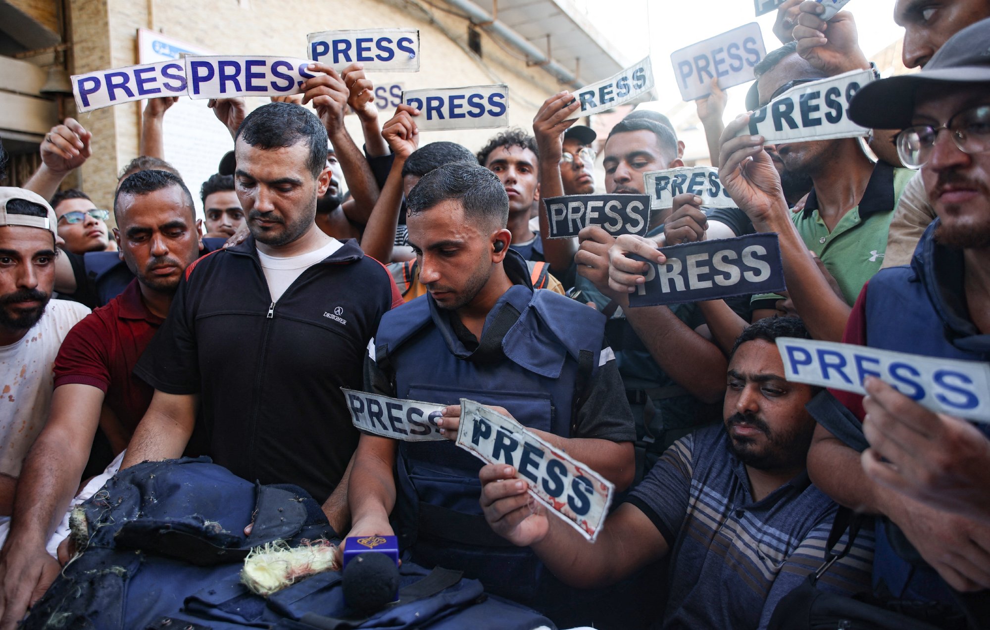 Un groupe de journalistes et de manifestants, brandissant des panneaux "PRESS".