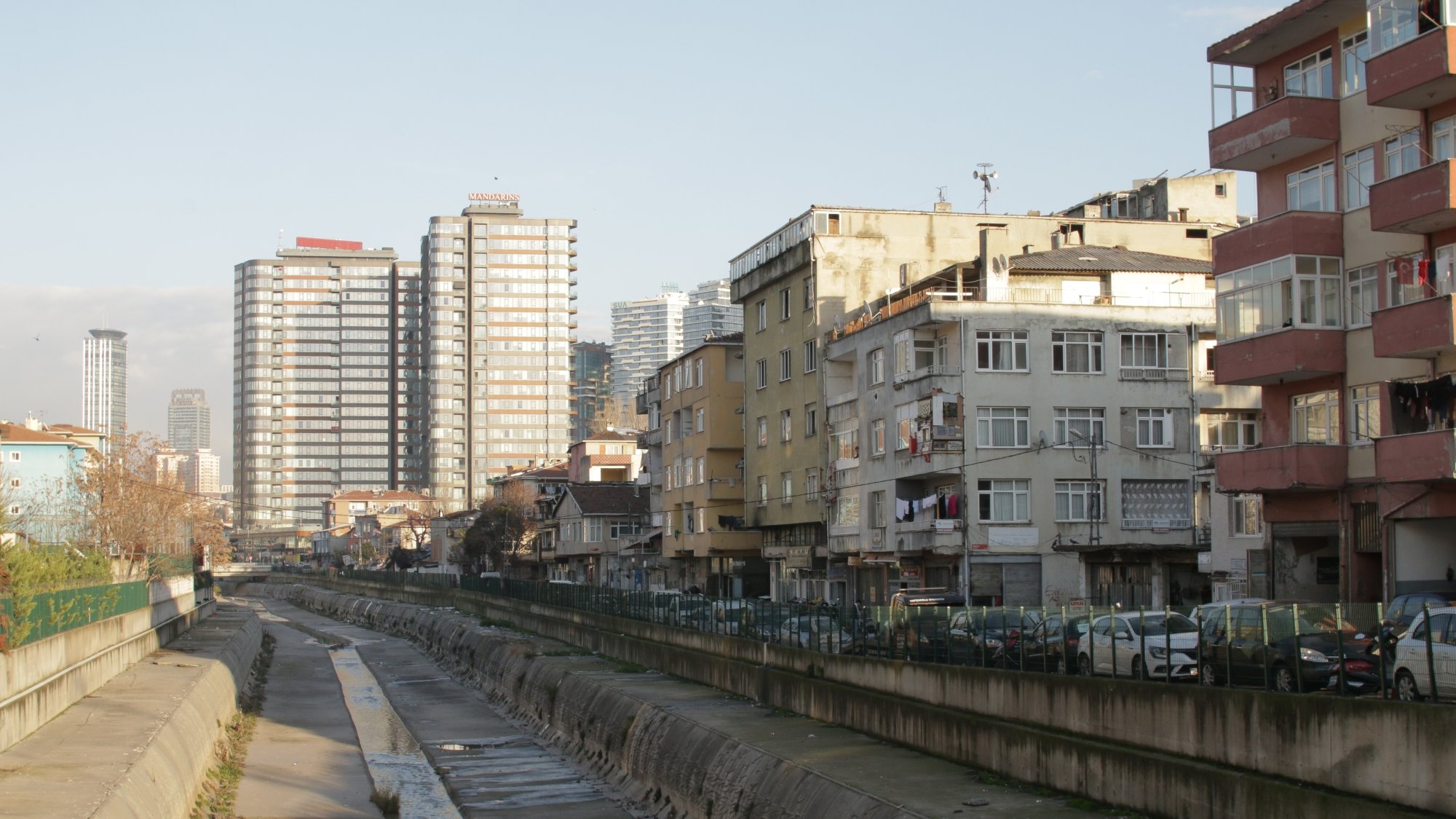 Vue d'une rue avec des immeubles modernes et des bâtiments anciens, le tout au bord d'un canal.