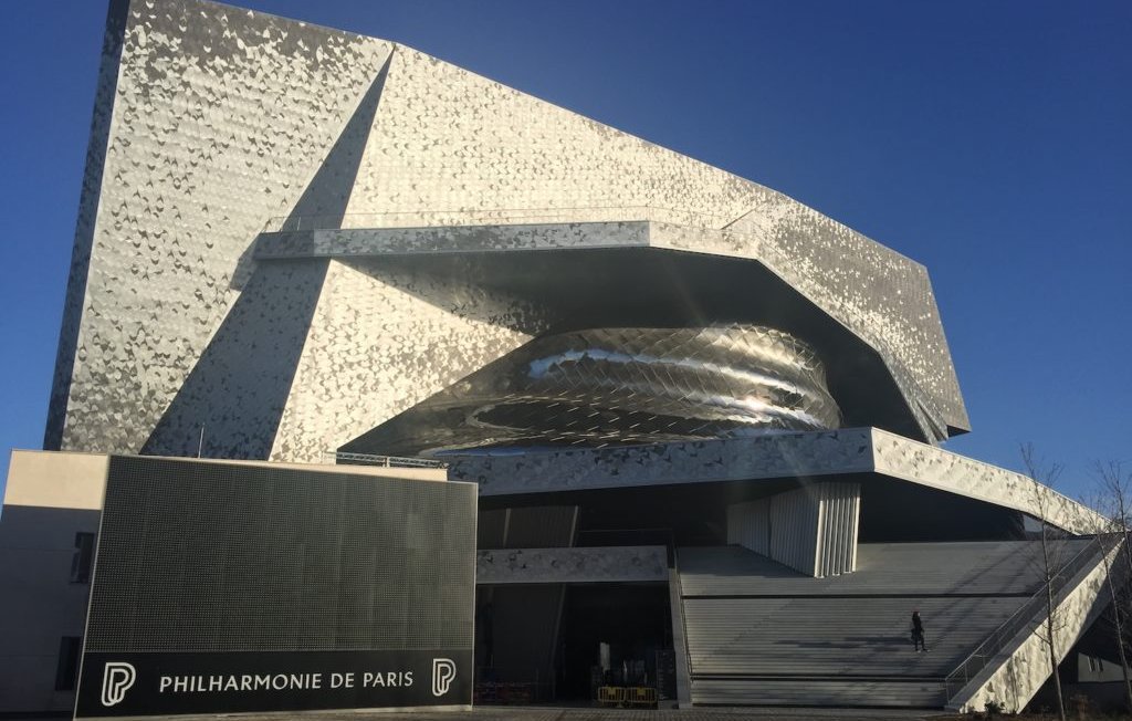 Bâtiment moderne aux formes ondulées, façade métallique, situé à Paris.