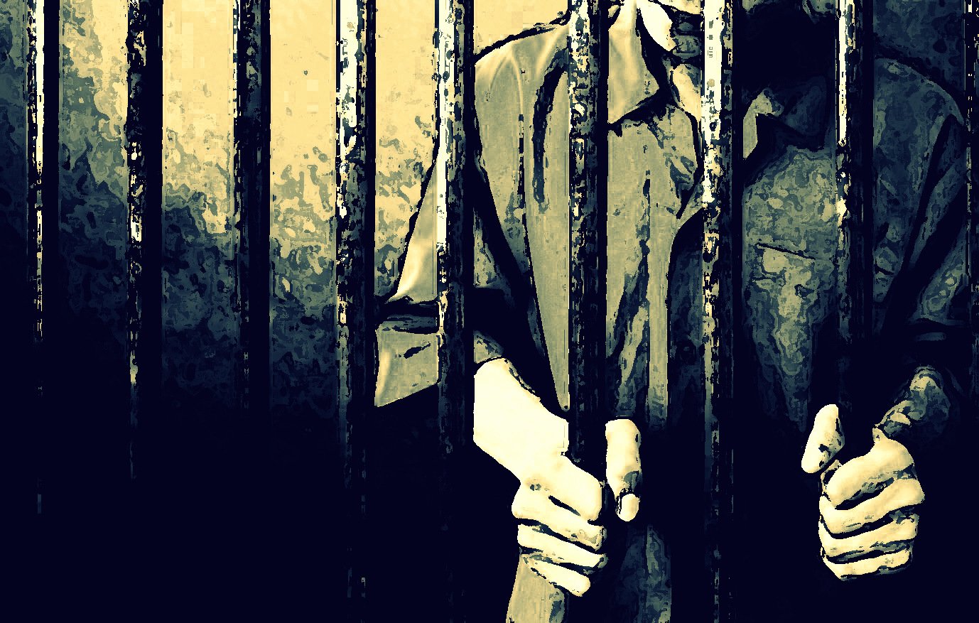 L'image montre des barreaux de prison, avec des mains qui s'agrippent à eux. Le fond est sombre et évoque une atmosphère de confinement. La personne derrière les barreaux est en partie visible, portant une chemise qui semble typique des uniformes de prison. L'éclairage crée des ombres, accentuant le sentiment d'isolement et de détention.