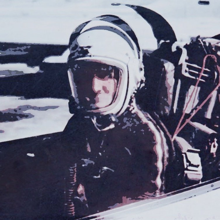 The image depicts a person seated in a cockpit, likely a pilot or astronaut. They are wearing a helmet and protective gear, suggesting they are preparing for a flight or mission. The background appears somewhat blurred, emphasizing the individual in the cockpit. The overall tone of the image conveys a sense of readiness and focus, typical of aviation or space exploration contexts.