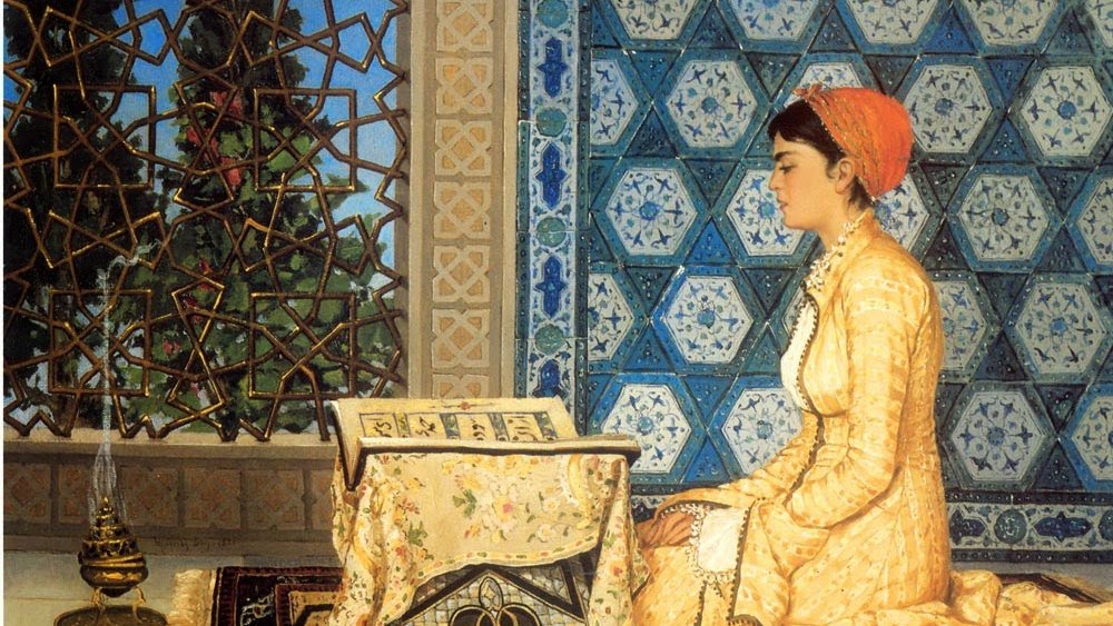 L'image représente une femme assise sur un tapis, dans un intérieur décoré de mosaïques aux motifs géométriques. Elle porte une robe élégante de couleur jaune et un foulard rouge. La femme est penchée vers un petit bureau sur lequel repose un livre. À côté d'elle, une lampe à huile apporte une touche chaleureuse à la scène. On peut apercevoir à travers une fenêtre ornée de motifs, des éléments de la nature, ce qui ajoute une ambiance paisible à l'ensemble.