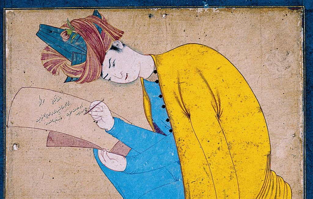 L'image représente un personnage assis, habillé d'un vêtement jaune et d'un pantalon bleu. Il semble concentré, en train d'écrire sur un morceau de papier qu'il tient dans sa main. Sa coiffure est ornée, et il adopte une pose réfléchie. Le fond est sobre, ce qui attire l'attention sur l'acte d'écriture et l'expression du personnage.
