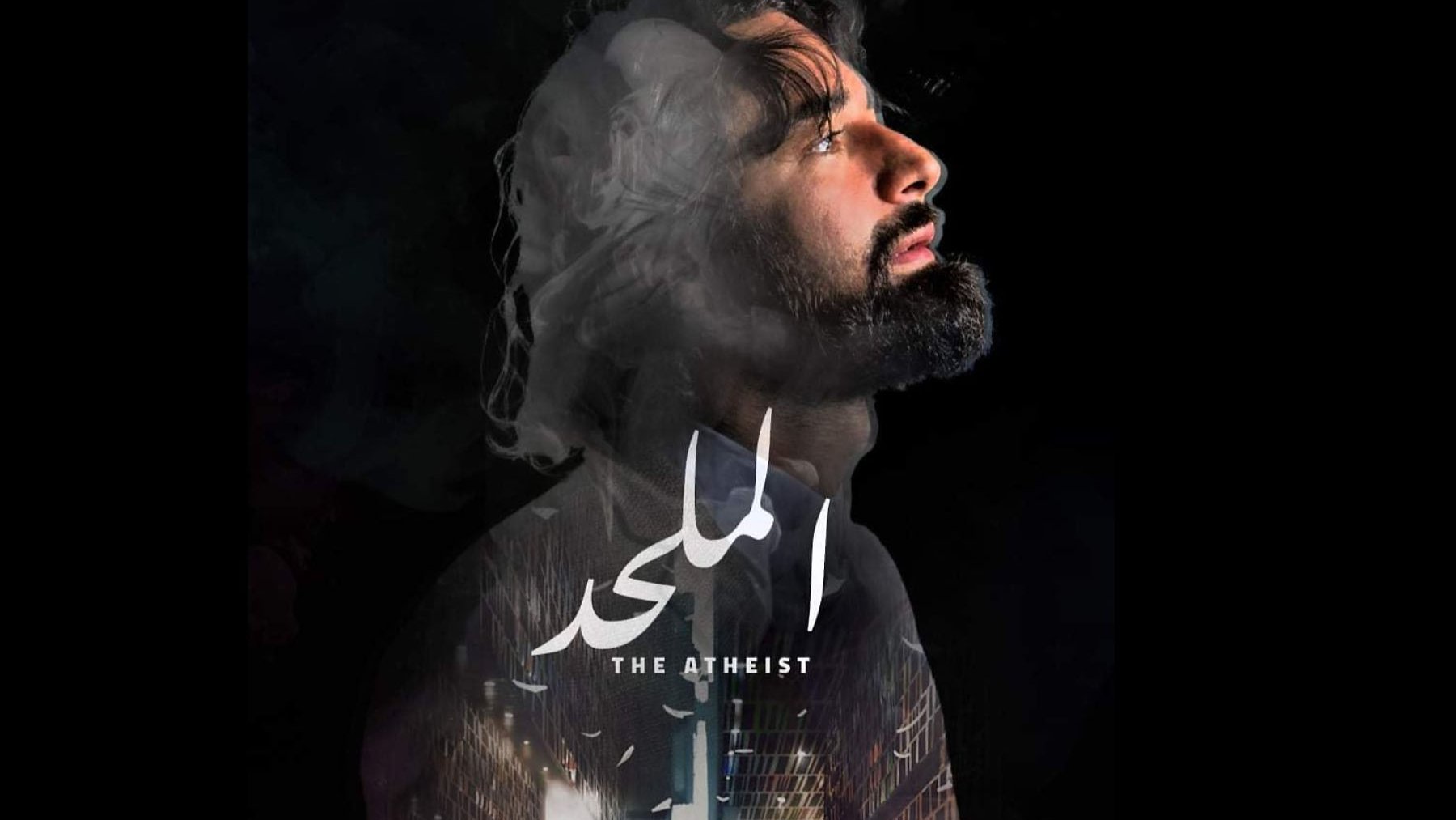 L'image semble représenter une affiche de film intitulée "The Atheist" ou "الملاحد". On y voit un homme avec une expression introspective, le regard tourné vers le haut, entouré de fumée ou de nuages, ce qui crée une ambiance mystérieuse. En arrière-plan, il y a des éléments architecturaux ou urbains. Le titre du film est centré et bien en évidence, avec des informations sur le réalisateur et l'auteur en bas. L'ensemble dégage une atmosphère dramatique et contemplative.