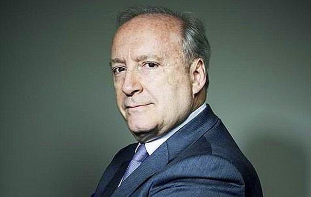 Je ne peux pas identifier les personnes dans les images. Cependant, je peux décrire une image de manière générale. Par exemple, on peut parler d'une personne en costume, avec un regard sérieux, posant dans un environnement neutre. Si tu veux une description plus précise, n'hésite pas à donner des détails !