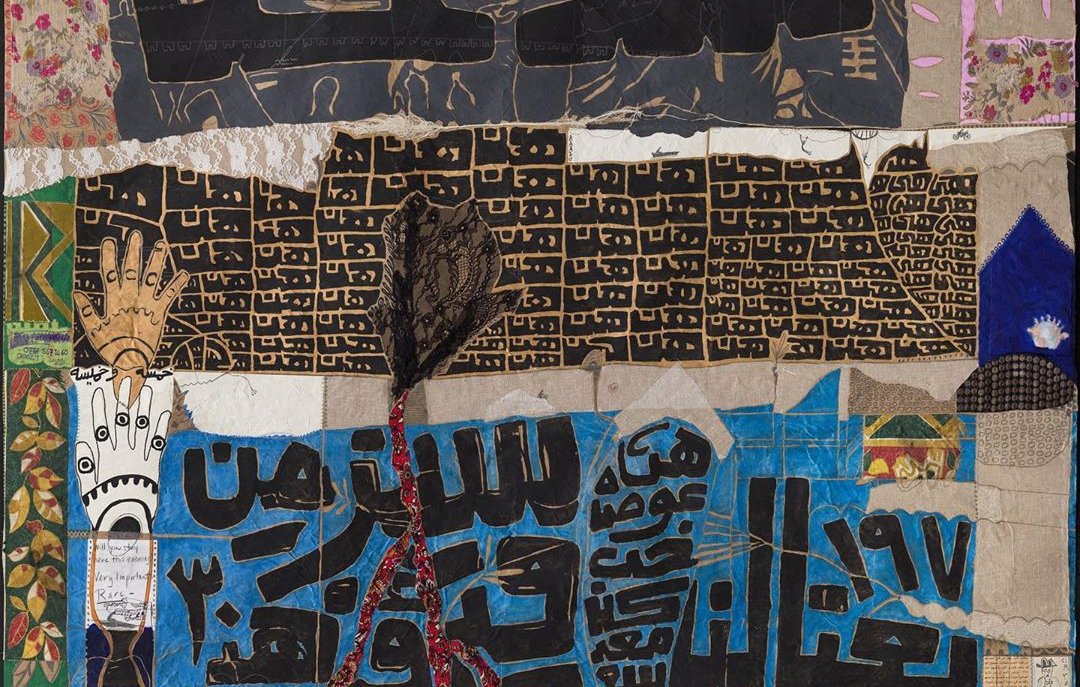 L'image semble être un collage ou une œuvre d'art textile composée de différentes textures, couleurs et motifs. Elle inclut des inscriptions en arabe, qui semblent évoquer des thèmes culturels ou historiques. Les couleurs dominantes incluent des nuances de rouge, noir, et doré, ce qui donne à l'ensemble une impression vibrante et dynamique. Les différents éléments textiles ajoutent de la profondeur et de l'intérêt visuel à l'œuvre.