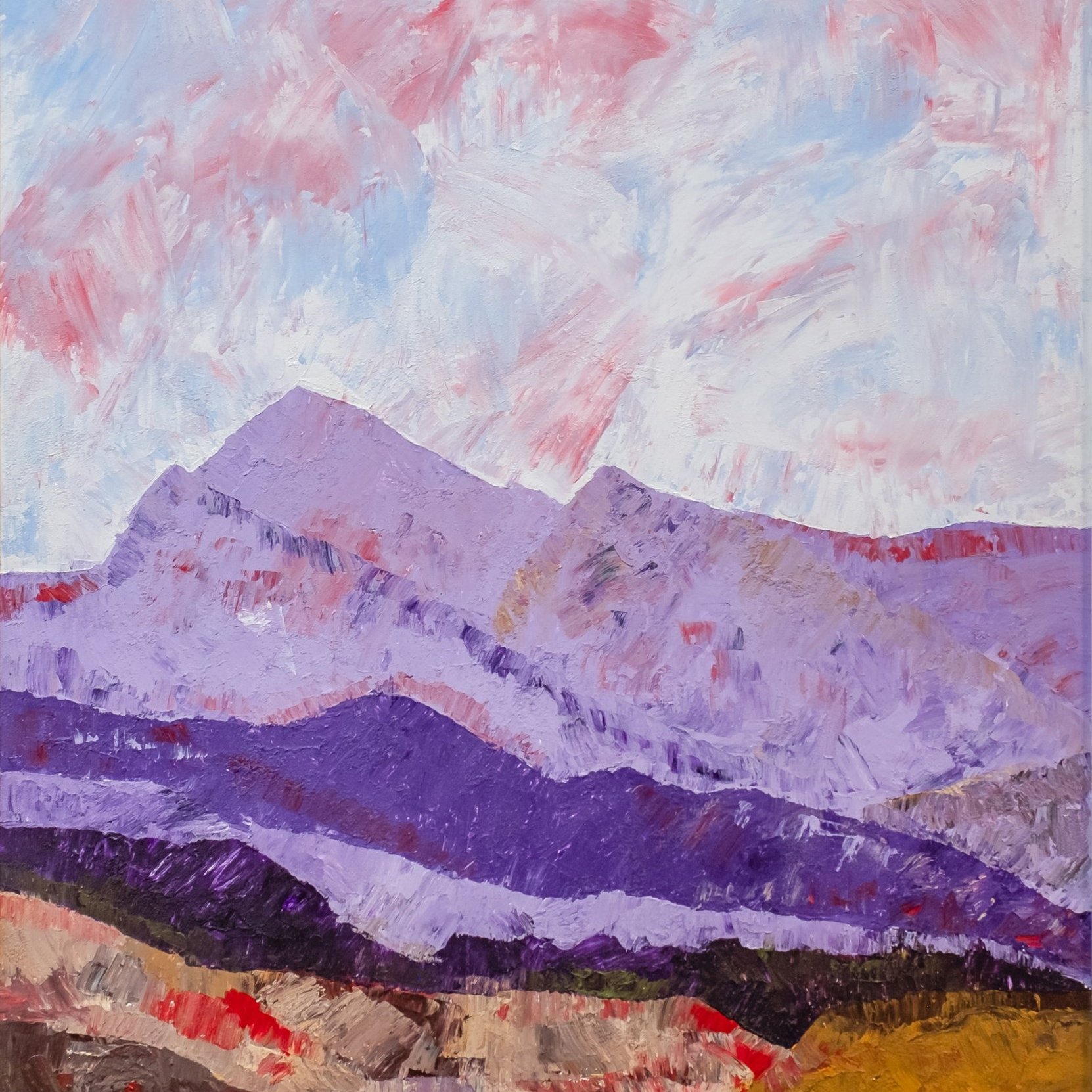 Paysage montagneux aux teintes violettes et rougeâtres sous un ciel nuageux.