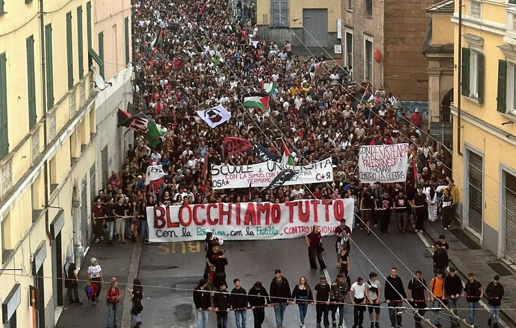 Une grande manifestation avec des milliers de personnes et des banderoles dans la rue.