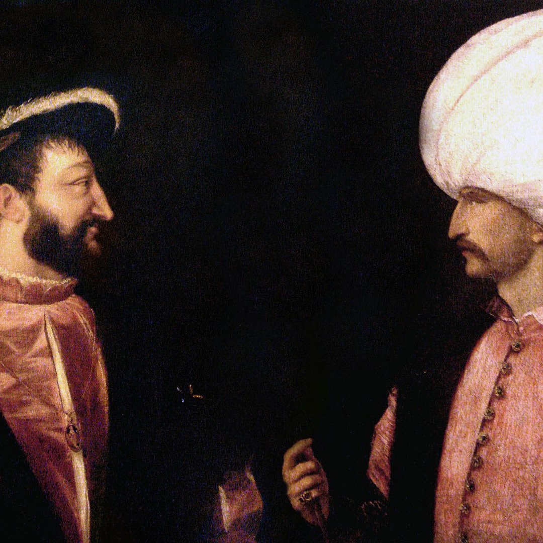 L'image représente deux figures historiques en conversation. À gauche, un homme européen, habillé de manière élégante, porte un chapeau à large bord et semble s'adresser à l'autre homme. À droite, un homme en vêtement traditionnel ottoman, portant un turban emblématique, affiche une expression sérieuse. Le fond est sombre, mettant en valeur les détails des costumes et les traits des personnages, suggérant une rencontre diplomatique ou un dialogue entre cultures.