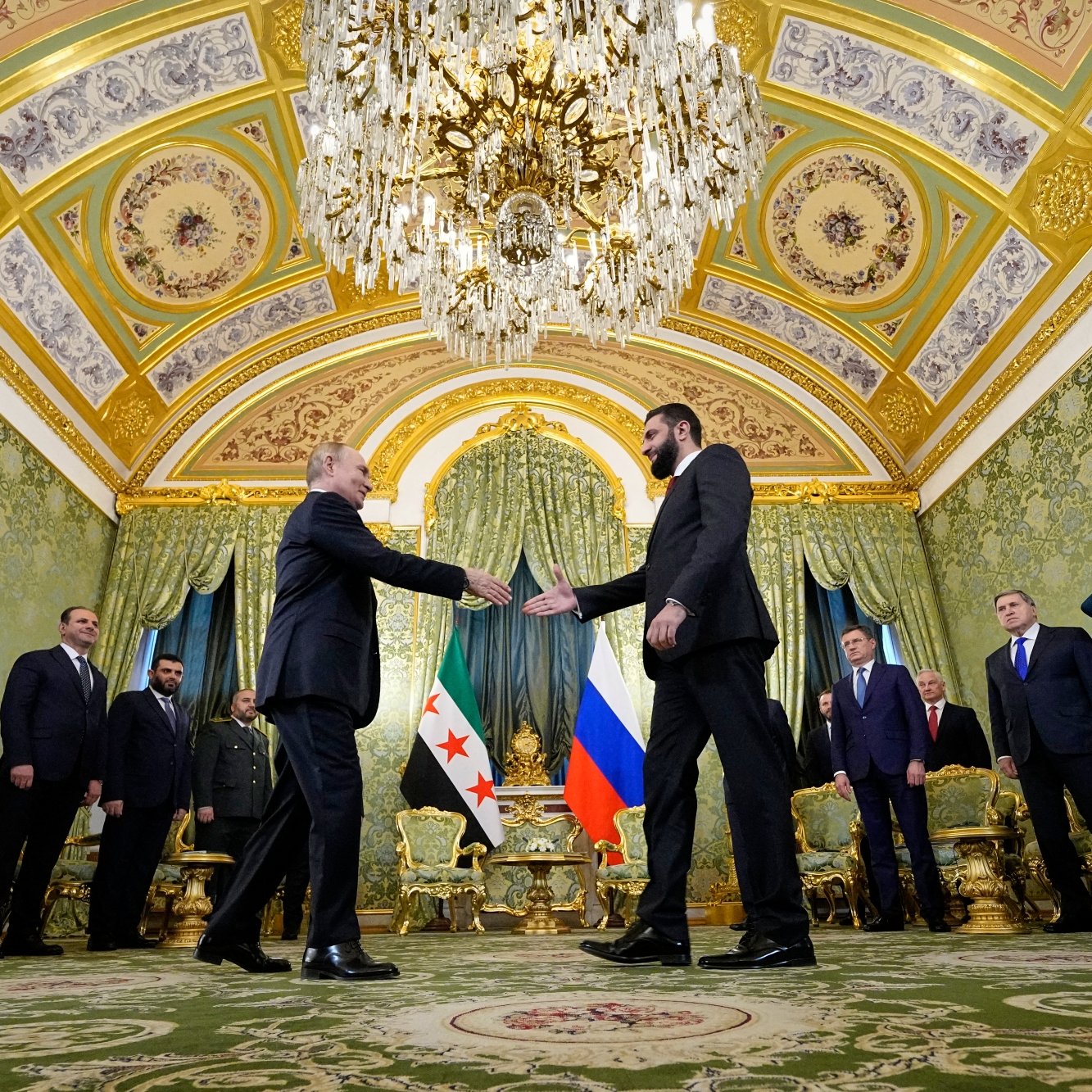 Réunion officielle dans une salle luxueuse, avec des drapeaux et des personnes en uniforme.