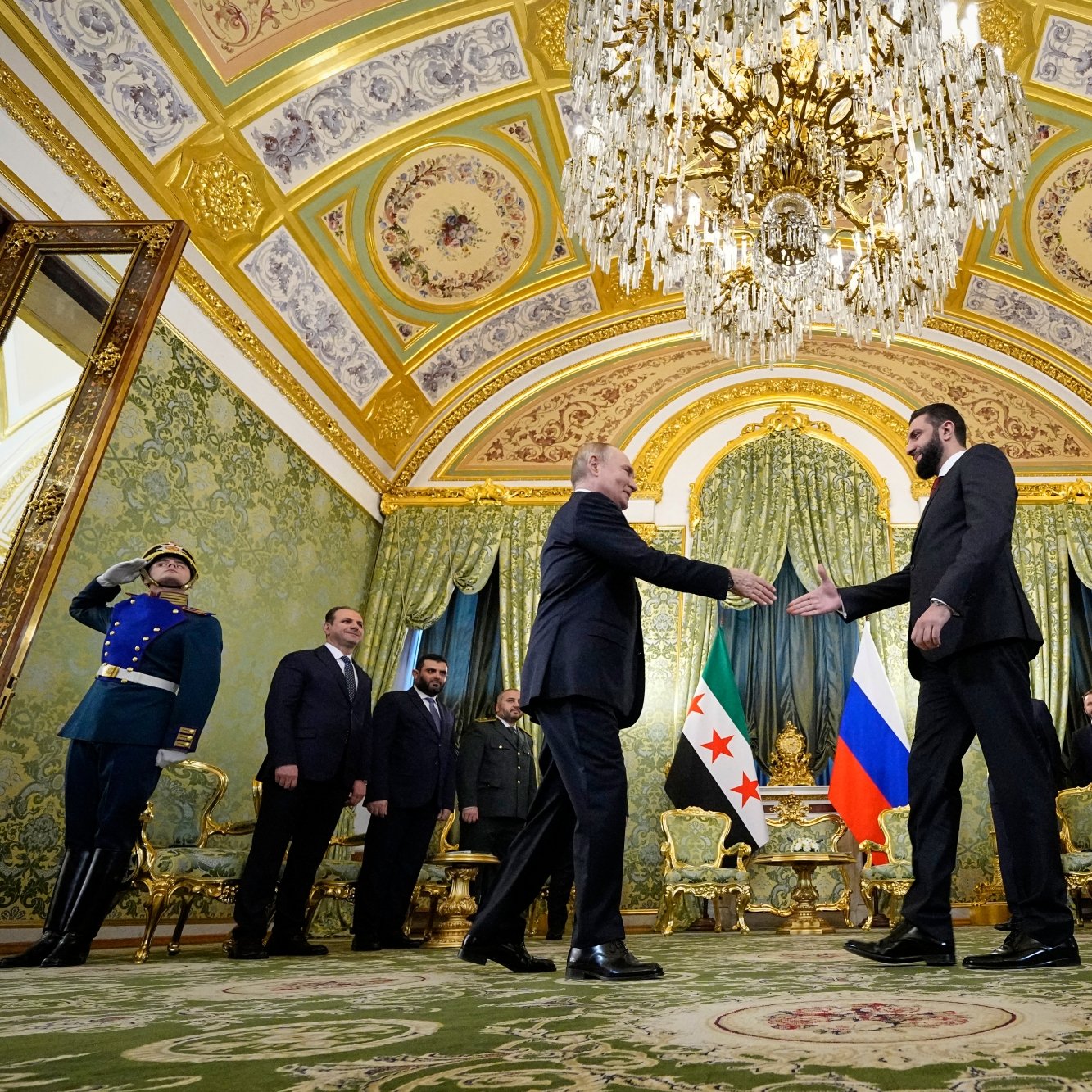 A formal meeting in an ornate room, with leaders shaking hands and military personnel in uniform.