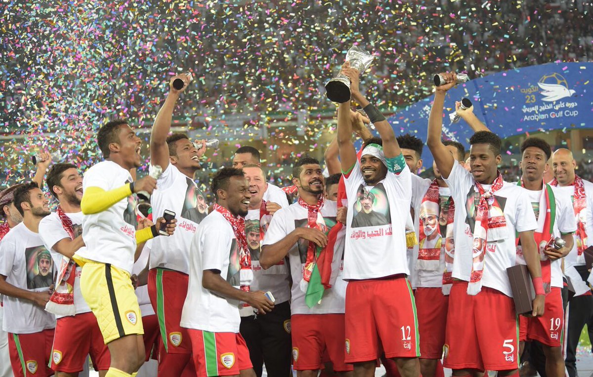 L'image montre une équipe de football célébrant une victoire. Les joueurs, vêtus de maillots assortis avec des t-shirts, levant un trophée en l'air, entourés de confettis multicolores. Ils semblent joyeux et enthousiastes, exprimant leur bonheur après avoir remporté un titre, probablement lors d'un tournoi ou d'une compétition. Les supporters en arrière-plan ajoutent à l'atmosphère festive.