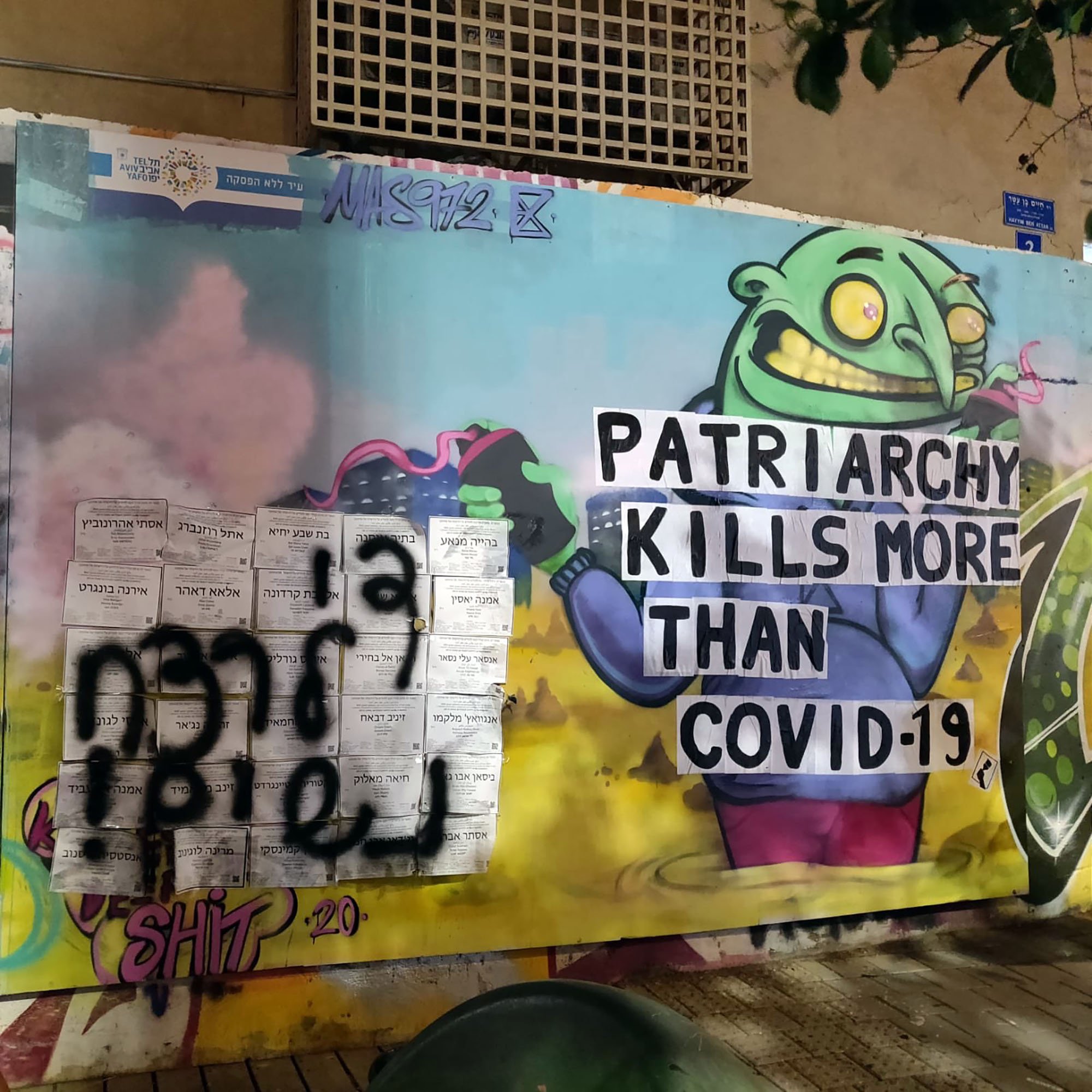 L'image représente une fresque murale colorée et expressive. On y voit un personnage caricatural avec une tête de monstre qui semble joyeux, tenant une pancarte sur laquelle il est écrit "PATRIARCHY KILLS MORE THAN COVID-19". À côté, il y a un graffiti en noir qui semble être écrit dans une autre langue. L'ensemble de l'œuvre rassemble des éléments de critique sociale et politique, mêlant humour et un message sérieux sur le patriarcat et la pandémie.