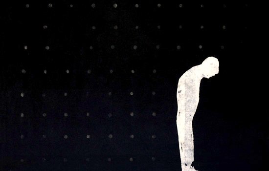 تظهر في الصورة خلفية سوداء داكنة، وفيها شكل أبيض لإنسان واقف. يبدو هذا الشخص مائلًا إلى الأمام، وكأنه يعبر عن الحزن أو الاستسلام. الخلفية تحتوي على نقاط صغيرة، مما يضيف عمقًا للصورة ويجعل التركيز أكثر على الشكل البشري. تعكس الصورة شعور الوحدة أو العزلة من خلال استخدام الألوان والتكوين البسيط.