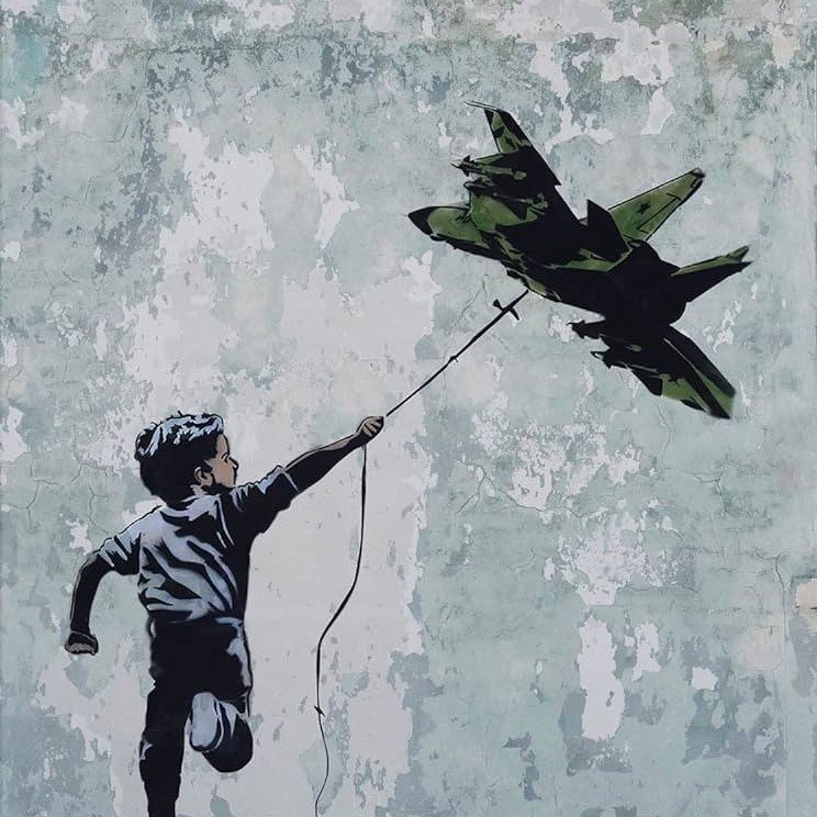 این تصویر گرافیتی را نشان می‌دهد که یک پسر بچه را در حال دویدن به سمت جلو و گرفتن یک هواپیمای جنگی در انتهای یک رشته نشان می‌دهد. پسر با شادابی و امید به این هواپیما نگاه می‌کند، در حالی که دیوار پشت‌ او دستخوش رنگ‌های کمرنگ و پوسته پوسته است. این اثر نشان‌دهنده‌ی تضاد بین Innocence (معصومیت) و جنگ است و می‌تواند تفکرات عمیق‌تری درباره‌‎ی صلح و جنگ را برانگیزد.