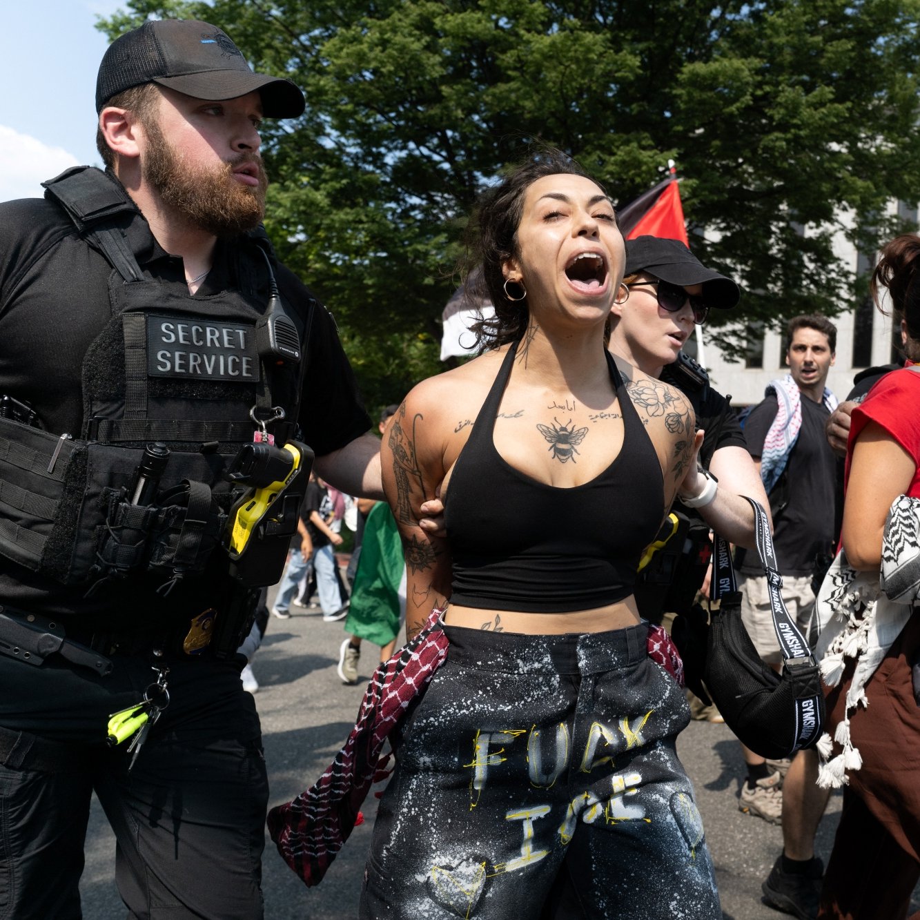 Manifestation intense avec des personnes interpellées par des agents de sécurité.