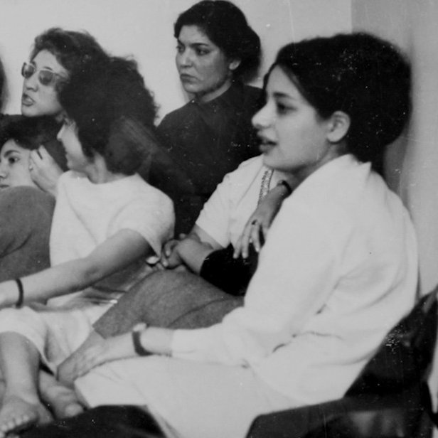 Un groupe de femmes assises, discutant et écoutant attentivement, visages concentrés.