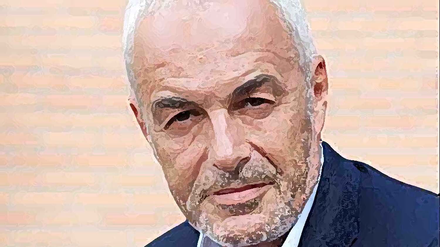 Je ne sais pas qui est cette personne, mais l'image présente un homme avec des cheveux gris et une barbe légèrement poivrée. Il a l'air sérieux et regarde directement l'objectif. Il porte un blazer sombre sur une chemise, et le fond semble aux teintes claires.