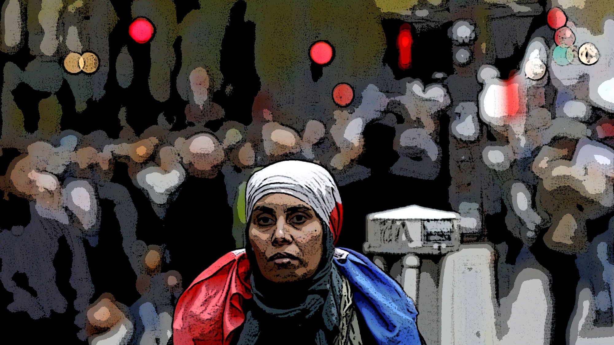 The image features a woman in the foreground wearing a white headscarf and a scarf that appears to have the colors of the French flag draped around her shoulders. She has a serious expression as she looks directly at the camera. The background is somewhat blurred and depicts a bustling crowd, suggesting a lively or busy environment, possibly a city street. The overall composition conveys a sense of solidarity or national identity amid a dynamic setting.