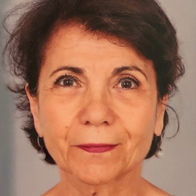 Femme d'âge moyen, cheveux brun foncé, regard franc, légèrement souriante.