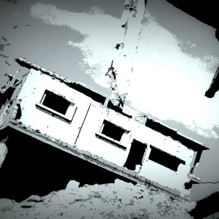 L'image montre un bâtiment en ruine, partiellement détruit, avec des murs endommagés et une atmosphère sombre. La structure semble en déséquilibre, suspendue ou penchée, ce qui renforce l'impression de dévastation. Le ciel est nuageux, ajoutant une tonalité dramatique à la scène. Les teintes sont principalement en noir et blanc, créant un effet visuel frappant.