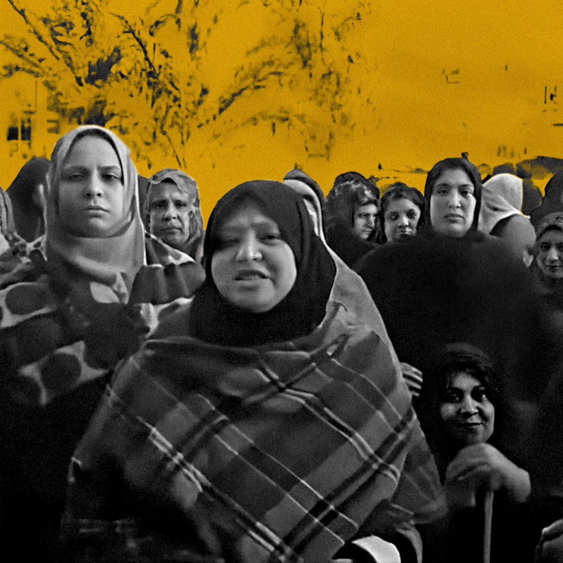 L'image montre un groupe de femmes, vraisemblablement en train de discuter ou de manifester. Elles portent des vêtements traditionnels et des foulards. Le fond est dominé par une teinte orange, ce qui crée un contraste avec les silhouettes des femmes. Leur expression semble sérieuse, et l'ensemble de l'image évoque une atmosphère de solidarité ou de revendication.