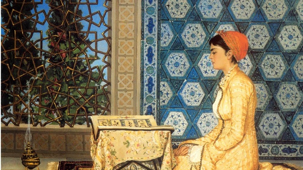 L'image présente une femme assise sur un tapis, vêtue d'une robe jaune ornée de motifs délicats. Elle est concentrée, tournant son regard vers un livre posé sur une table basse. La pièce est décorée avec de magnifiques mosaïques murales bleues et un vitrail qui laisse passer une lumière douce. À côté d'elle, une lampe à huile ajoute une touche d'ambiance chaleureuse. L'atmosphère générale dégage une impression de sérénité et de dévotion.
