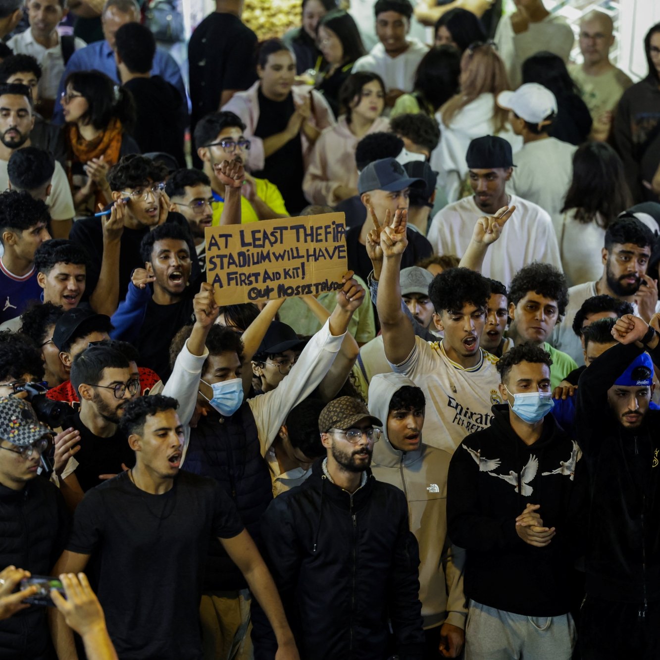 Un groupe de jeunes manifestants agitant des pancartes lors d'un rassemblement animé.