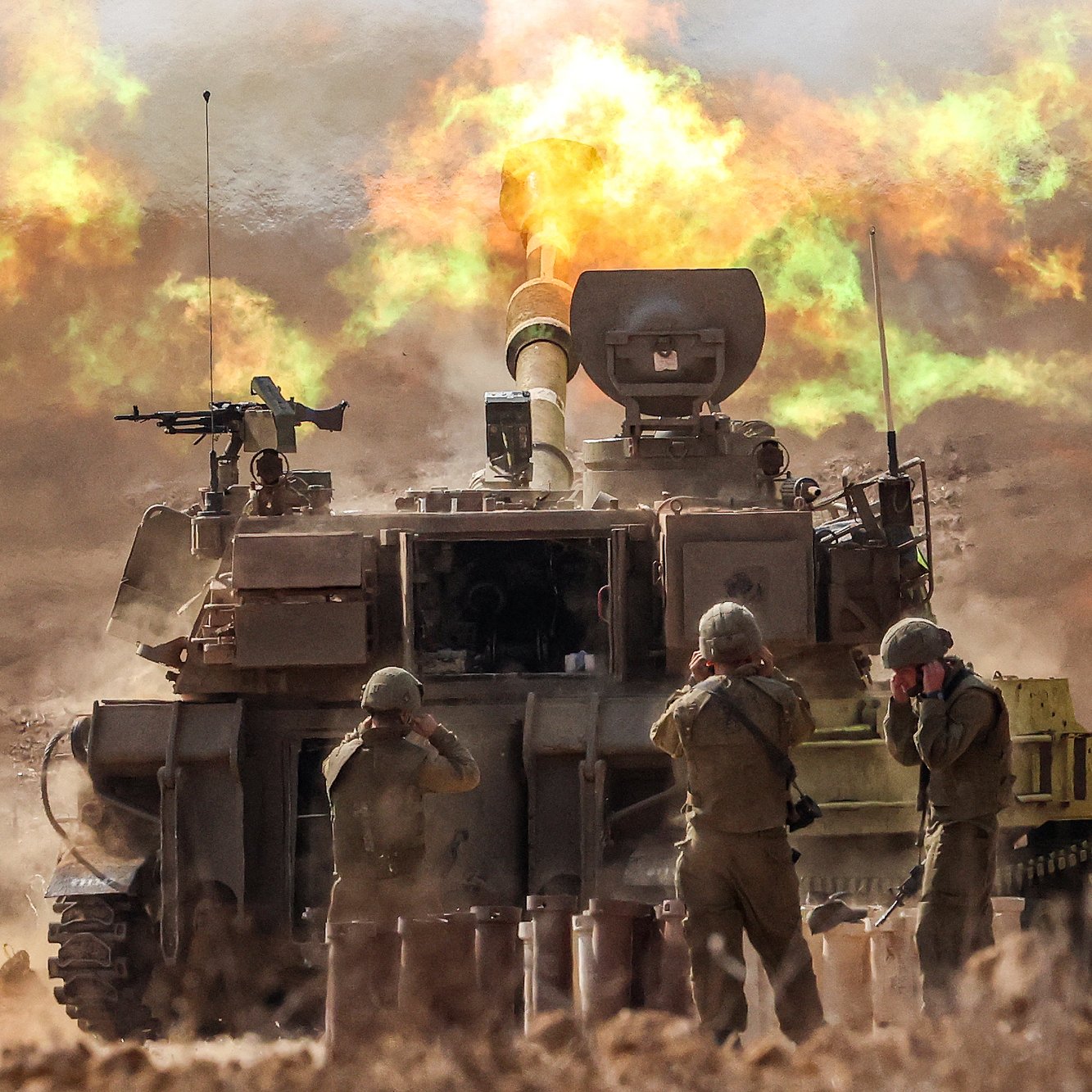 L'image montre un char de combat en action, probablement en train de tirer. Des soldats en uniforme sont présents près du char, occupant des positions de tir ou se préparant à l'action. En arrière-plan, des explosions et des flammes se produisent, créant une atmosphère intense et chaotique. La scène évoque un environnement militaire, avec une ambiance de conflit et de mouvement.