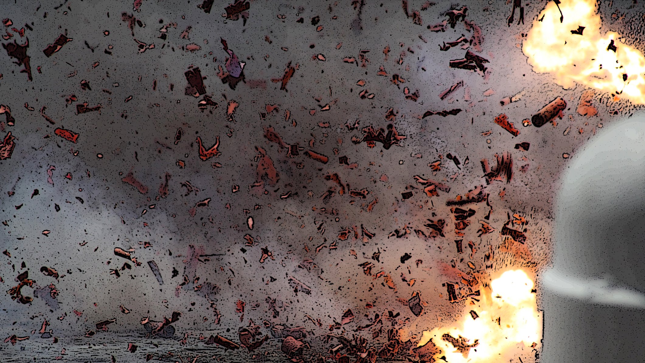 The image depicts an intense explosion, with fragments and debris scattered throughout the scene. There are bright flashes of light indicating the force of the blast, and the background appears smoky and chaotic, suggesting a highly energetic event. The overall atmosphere conveys a sense of destruction and turmoil.