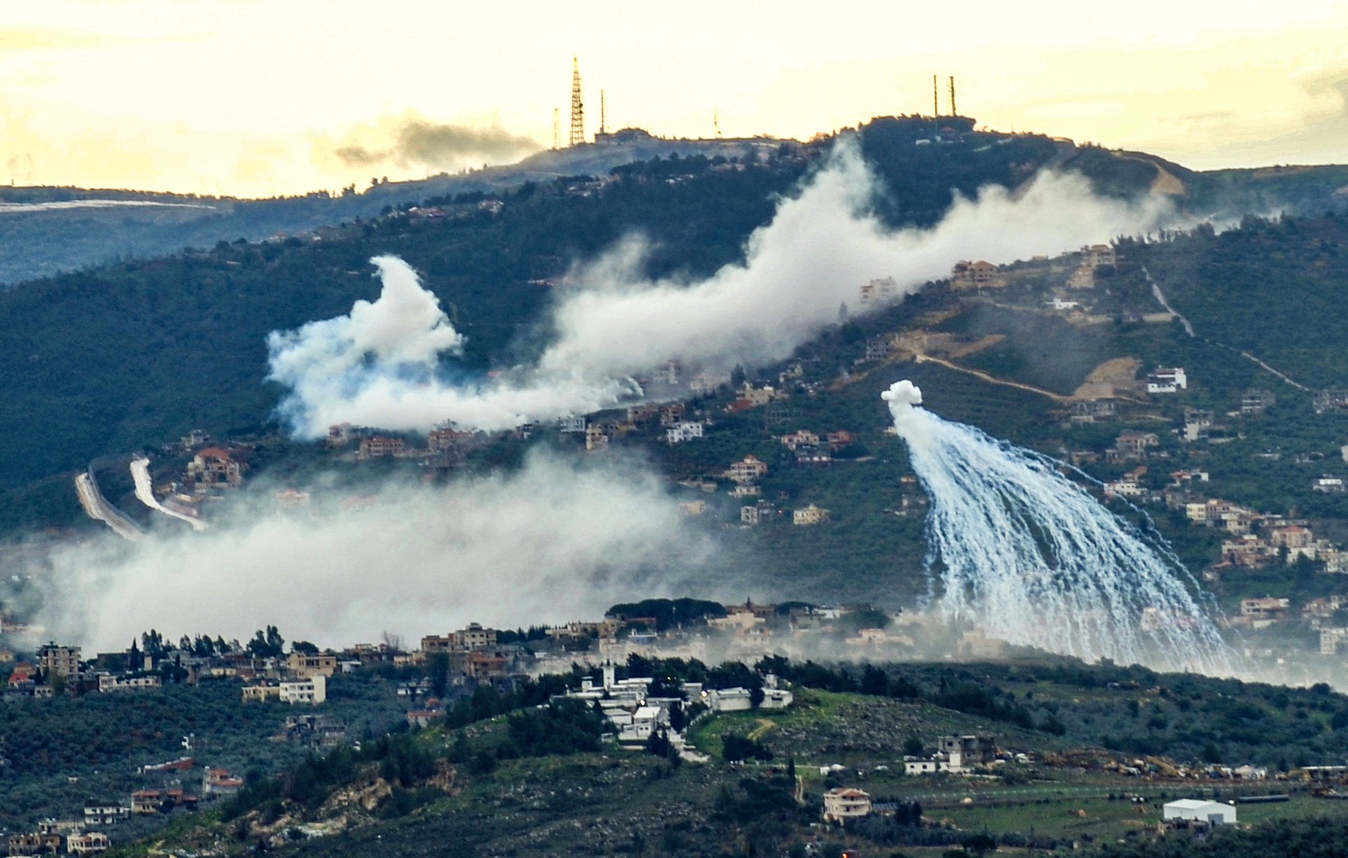 Nuages de brume et jets d'eau sur une colline, paysage montagneux.