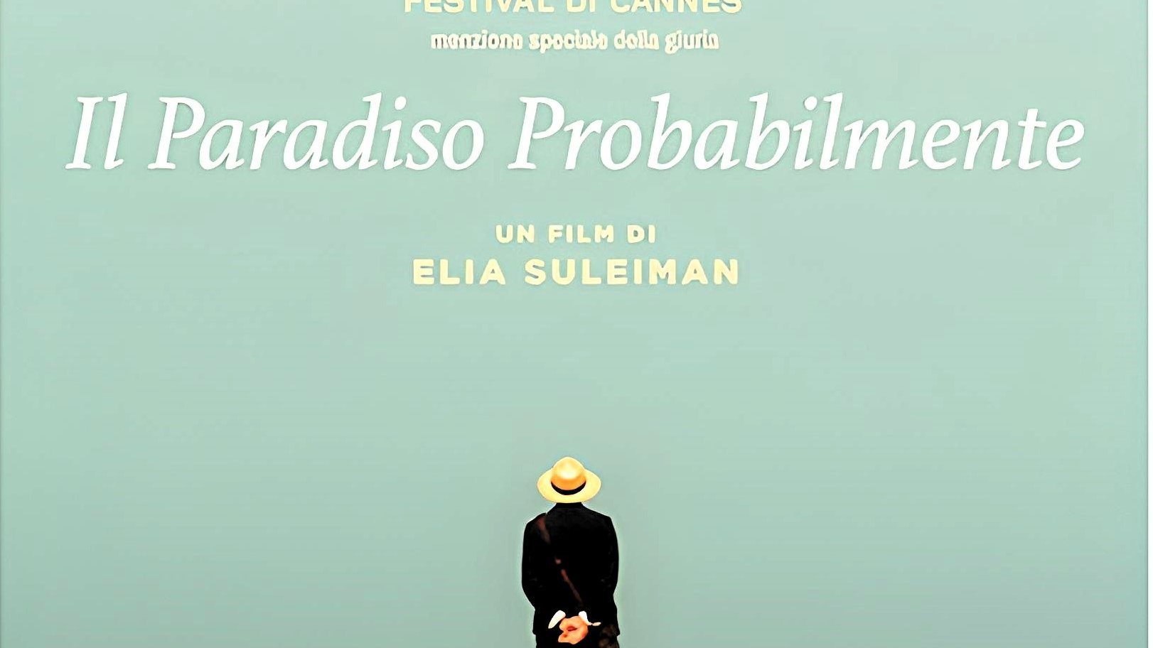 L'immagine sembra rappresentare un poster di un film intitolato "It Must Be Heaven", diretto da Elia Suleiman. In primo piano, c'è una figura umana di spalle, vestita con abiti leggeri e un cappello, che si trova su una scogliera e osserva l'orizzonte. Sullo sfondo, si vede un cielo sereno e un mare blu, creando un'atmosfera di tranquillità e contemplazione. Il titolo del film e il nome del regista sono scritti in caratteri chiari, dando risalto alla scena.