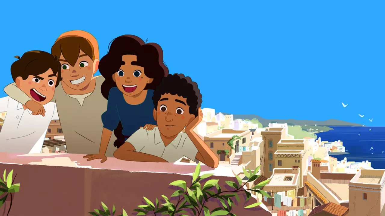 Quatre enfants souriants posent sur un mur avec une vue sur la mer et des maisons.