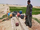 أحد المزارعين بجوار ماكينة ومأخذ مياه جوفية بإستخدام الجازولين في قرية القارة شمالي محافظة قنا.