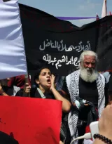 Une manifestation avec des drapeaux, des pancartes et des participants engagés.