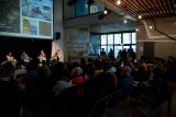 Un débat animé avec un public attentif dans une salle moderne et lumineuse.