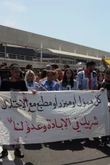 Des manifestants portent une grande banderole en criant des slogans.