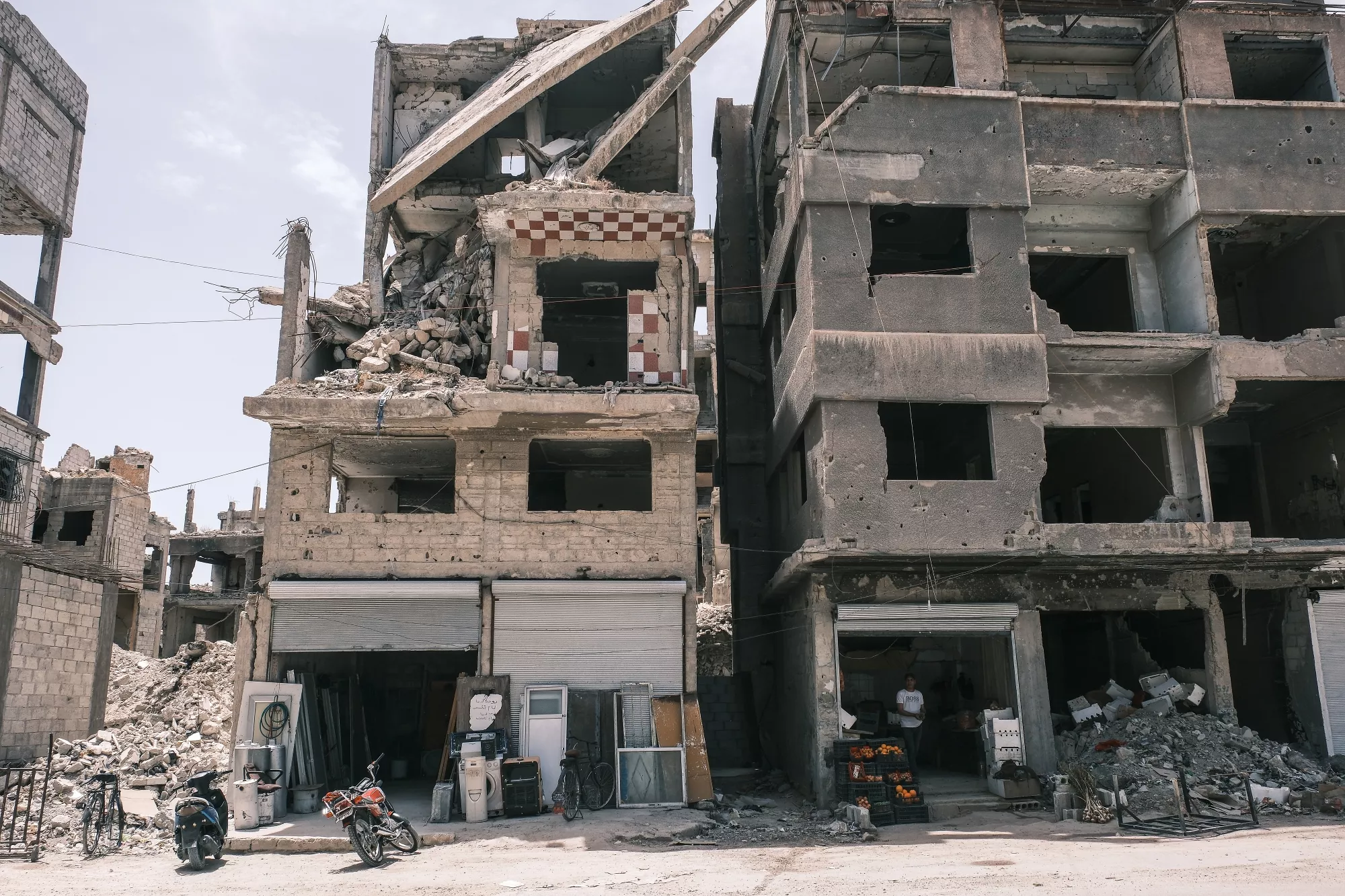 Edifici in rovina, detriti sparsi, un'atmosfera di distruzione.