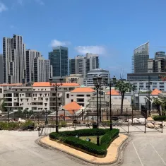 A cityscape featuring modern skyscrapers, residential buildings, and landscaped areas.