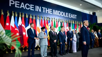 Des dirigeants présents devant un mur avec le texte "PAIX AU MOYEN-ORIENT" et des drapeaux.